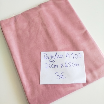 Retalho de tecido rosa com etiqueta descritiva sobre superfície branca
