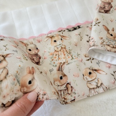Manta para bebé com padrão de coelhos e borda branca com fita rosa