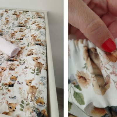 Lençol elástico com padrão de animais da floresta em cores pastel e toalha branca enrolada num berço