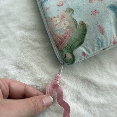 Bolsa com padrão marinho em tecido azul claro e fecho com puxador cor-de-rosa