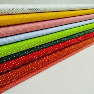 Pilha colorida de tecidos com bolinhas brancas