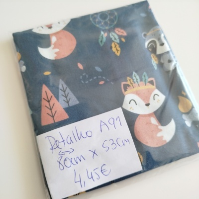 Retalho tecido azul com desenhos raposas e folhas com etiqueta manuscrita