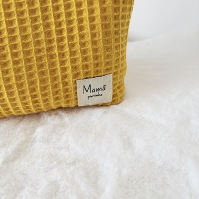 Pano amarelo mostarda com textura de waffle e etiqueta com texto Mamã pintinha
