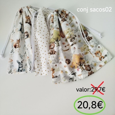 Quatro sacos de tecido estampados com cordões brancos sobre superfície branca.