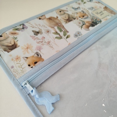 Estojo transparente com fecho azul claro e padrão com animais e flores