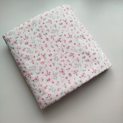 Tecido branco com padrão floral rosa e verde dobrado