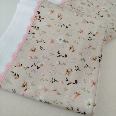Máscara de tecido com padrão floral pastel e detalhe rosa
