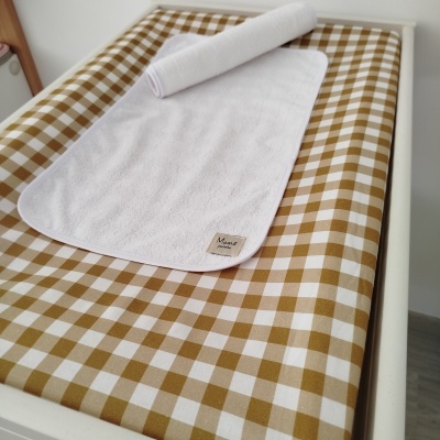 Tapete branco com etiqueta sobre superfície xadrez bege e branca em móvel branco