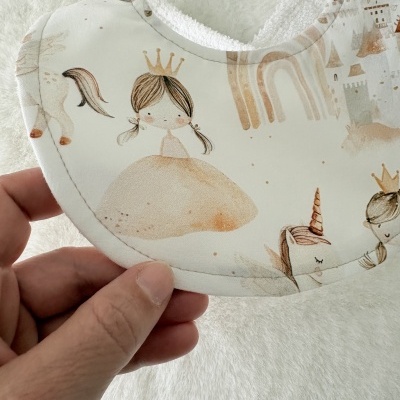 Babete branco e bege com estampado de princesa e unicórnio em tons pastel