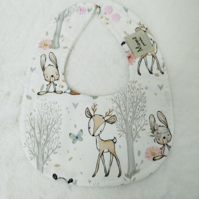 Babete branco com padrão de animais e árvores infantis