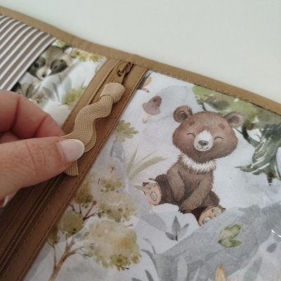 Pasta organizadora com fecho castanho e desenho de urso sorridente