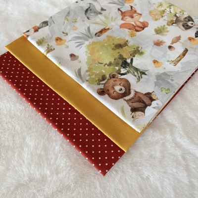 Três tecidos dobrados com padrões e cores diferentes sobre superfície branca macia