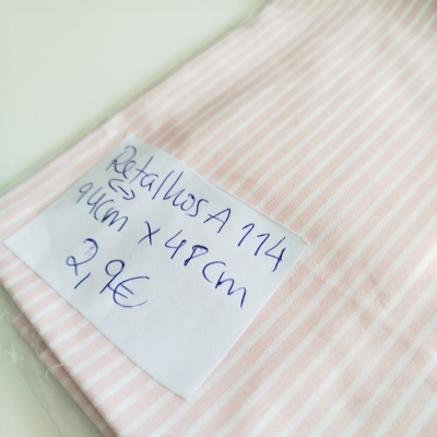 Pano de tecido rosa com riscas brancas e etiqueta escrita à mão.