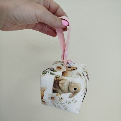 Mala pequena em tecido branco com padrão de coelhos e flores segurada por alça rosa