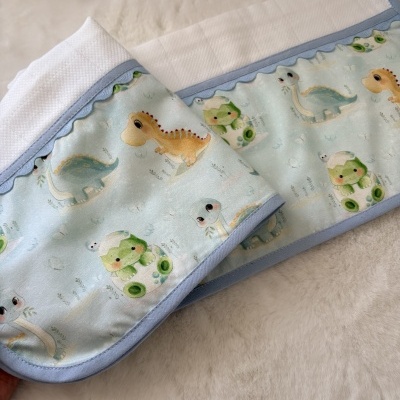 Manta para bebé azul com desenho de dinossauros e borda azul