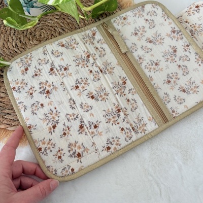 Organizador de tecido floral bege com fecho de correr perto de plantas