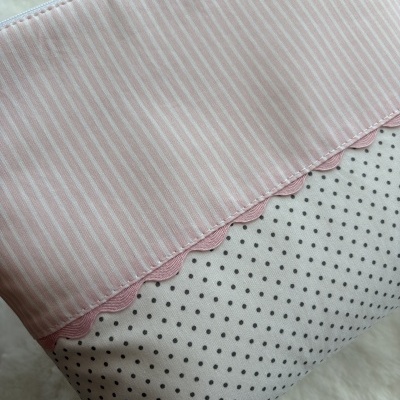 Necessaire com padrão de riscas e bolinhas e faixa ondulada