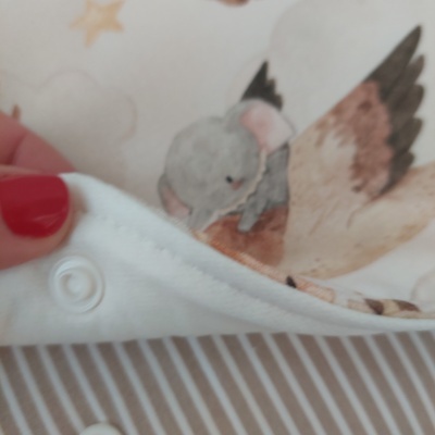 tecido branco com botão de pressão e estampa de pássaro e fundo com estrelas e nuvens