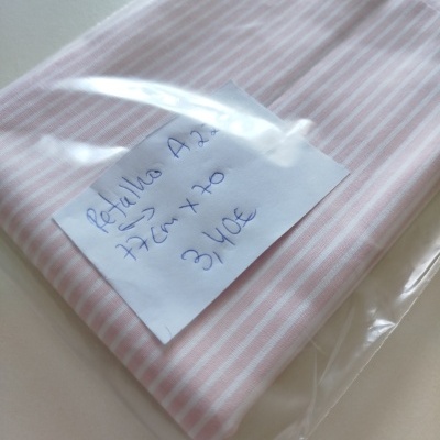 Pano de tecido riscado rosa e branco dentro de saco plástico com etiqueta manuscrita