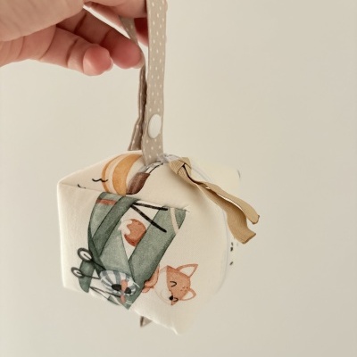 Mala pequena em tecido com padrão ilustrado de raposa e carrinho verde com alça bege e botão branco.