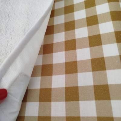 Pano branco texturizado com aba e tecido xadrez castanho e branco debaixo