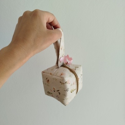 Pequena mala quadrada de tecido creme floral com alça