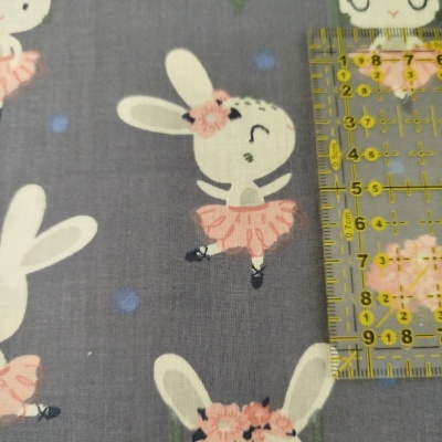 Tecido cinza com padrão de coelhos brancos em saia de balé rosa e flores cor-de-rosa.