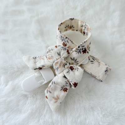 Argola para chupeta de tecido branco com padrão floral castanho e fecho branco