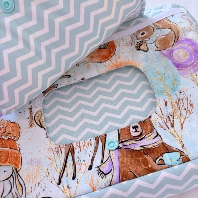 Babete azul clarinho com padrão zig zag e estampado de animais com cachecol