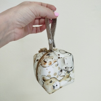 Bolsa pequena com padrão de ursos em tons bege e castanho claro com alça e fecho de correr