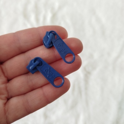 Dois puxadores de fecho éclair azuis em plástico com inscrição