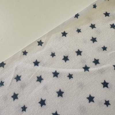 Tecido branco com estrelas pretas