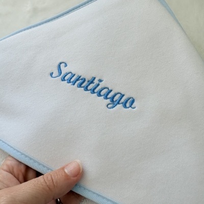 Toalhete branco com borda azul e nome bordado Santiago