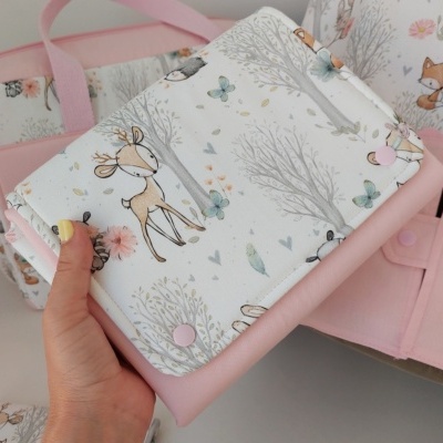 Carteira branca com padrão de cervos e elementos naturais em rosa claro