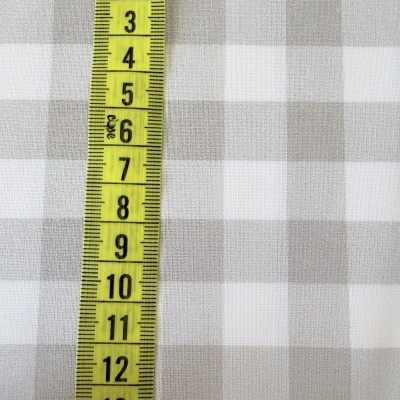 Pano xadrez cinza e branco com fita métrica amarela