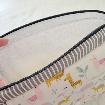 Bolsa infantil com padrão de animais e fecho de correr