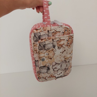Porta-objetos em tecido com padrão de animais e alça rosa com detalhes brancos