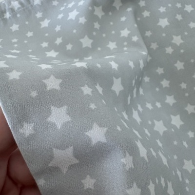 Tecido cinzento com estrelas brancas, textura suave