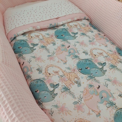 Cama de bebé com edredão e almofada com padrão de animais e tecido almofadado rosa