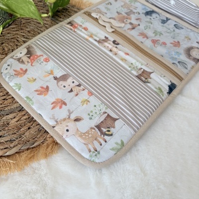 Organizador tecido com padrão de animais e riscas sobre tapete branco