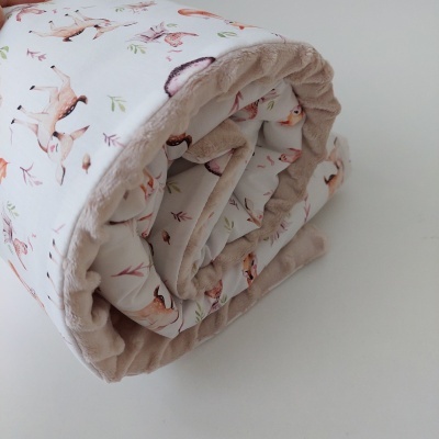 Edredão ou manta dobrada com padrão de animais e tecido felpudo.