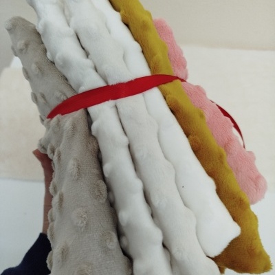 Conjunto de mantas coloridas amarradas com fita vermelha