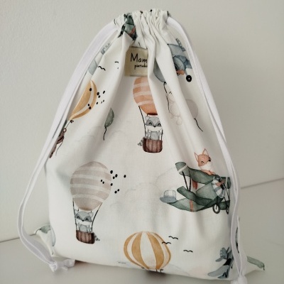 Mochila saco tecido branco com desenho de balões e aviões em tons pastel