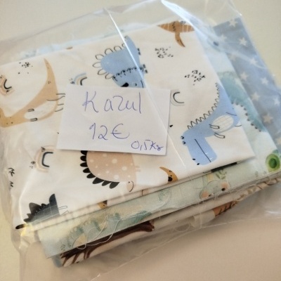 Pacote de tecidos com estampados de dinossauros em saco plástico e nota manuscrita