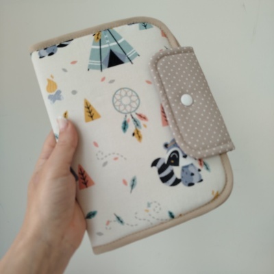 Carteira de tecido branco com estampas coloridas e fecho bege com botão de pressão