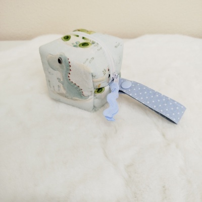 Estojo pequeno com padrão de crocodilos verdes e brancos e fecho com aba azul estrelada