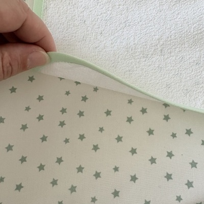 Toalha branca com borda verde e fundo com estrelas verdes.