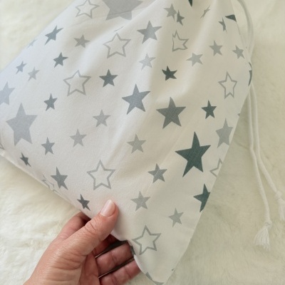 Saco de tecido branco com estrelas cinzentas e cordão de fecho