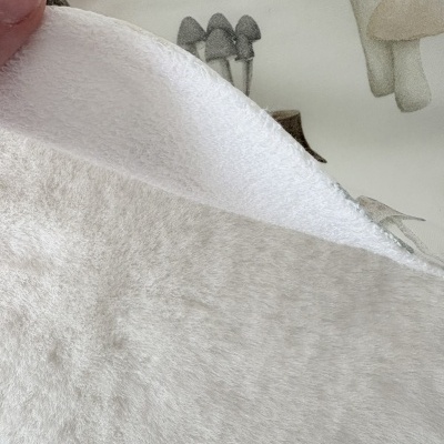Pano branco texturizado e tecido estampado com cogumelos em tons pastel.