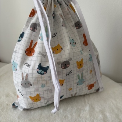 Mochila saco branca com estampas de animais e cordões brancos